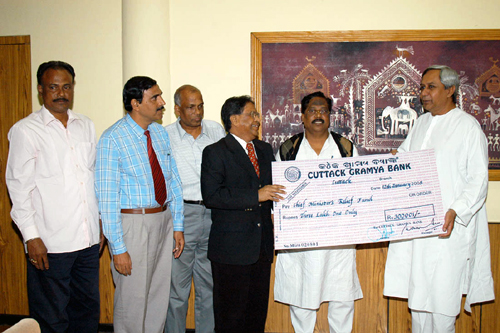 Naveen Patnaik receiving a cheque Rs. 3 Lakhs from Higher education Minister  Shri Sameer Dey on behalf of Cuttack Gramya Bank for Tsunami Victims.