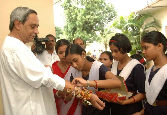 School Students tieing Rakhi on  the hands of Chief Minister Shri Naveen Patnaik on the occasion of Rakshya Bandhan at Naveen Nivas.