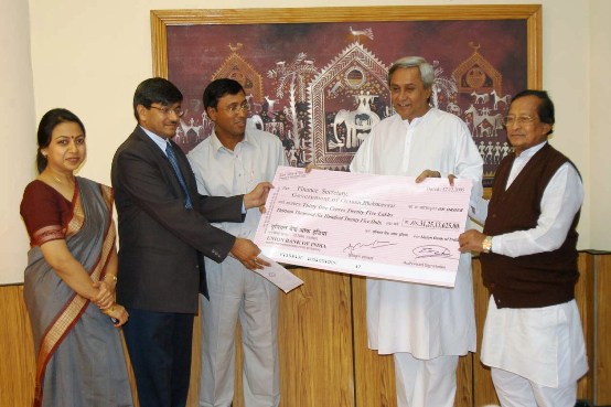 Naveen Patnaik receiving the Dividend Cheque of Rs. 31.25 Crores from  Chairman OPGC Shri Ashit Tripathi in the presences of Energy Minister Shri Surjya Narayan Patro at Secretariat.